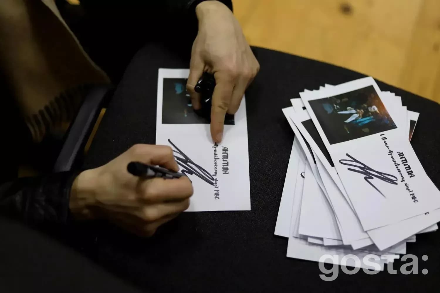 Ліцеїст підписує листівки із зображенням гурту «Антитіла» на зустрічі в Івано-Франківську.