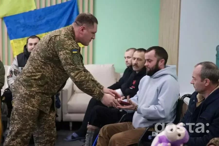 Бригадний генерал Нацгвардії вручає нагороду пораненому воїну в лікарні, Україна.