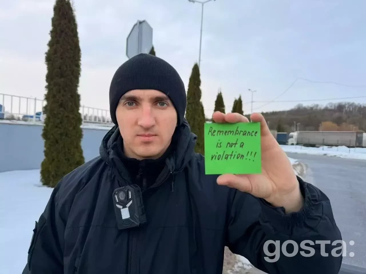 Я не можу визначити особу на зображенні, але можу описати його:

Зображення чоловіка, який тримає напис «Remembrance is
