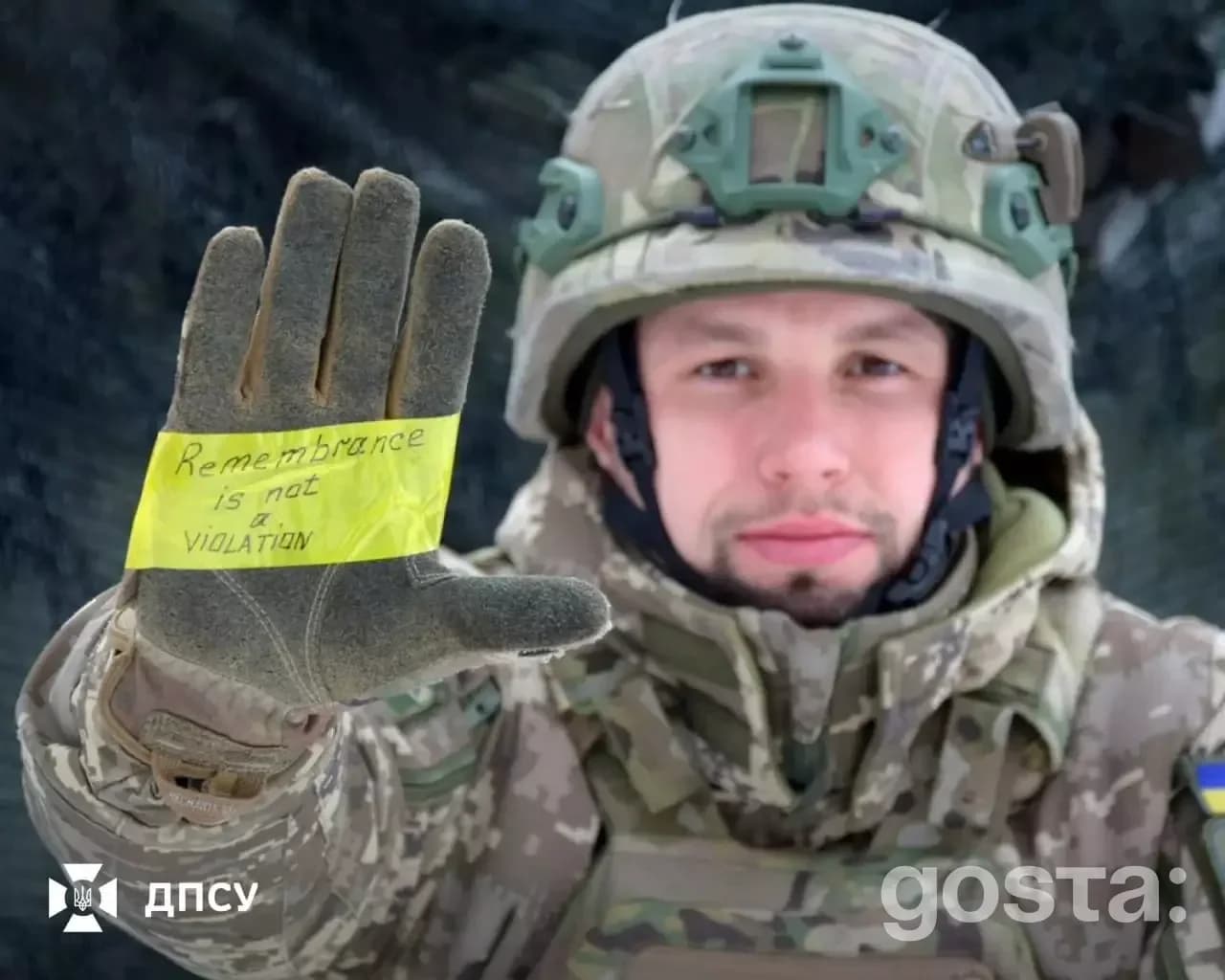 Військовослужбовець в уніформі тримає руку з написом «Remembrance is not a violation», підтримуючи Владислава Гераскевич