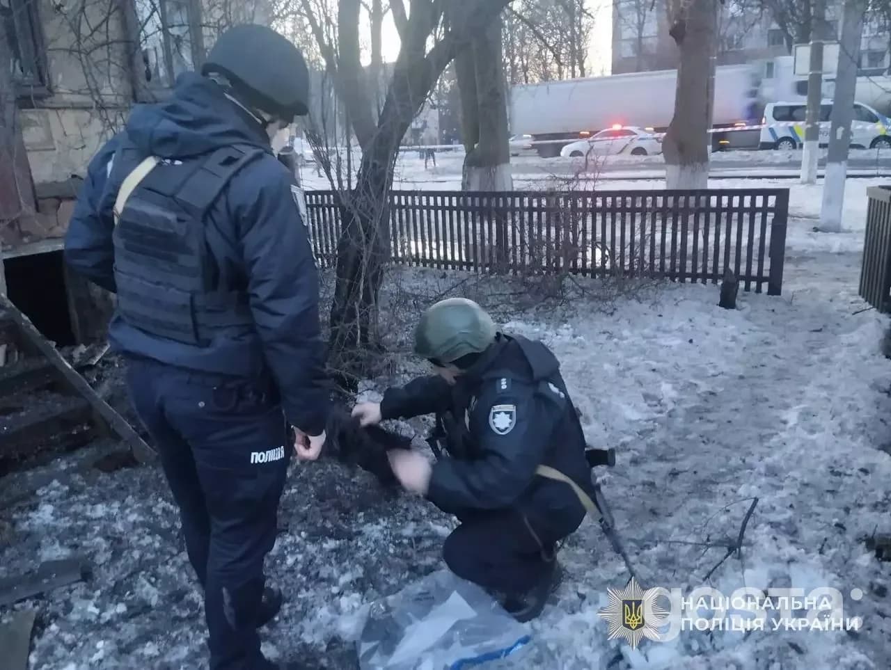 Поліцейські документують наслідки обстрілів у засніженому дворі на Київщині, працюючи на місці атаки.