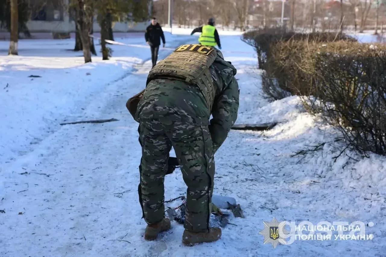Поліцейський фіксує наслідки обстрілів на Київщині; зима, сніг, військова форма.