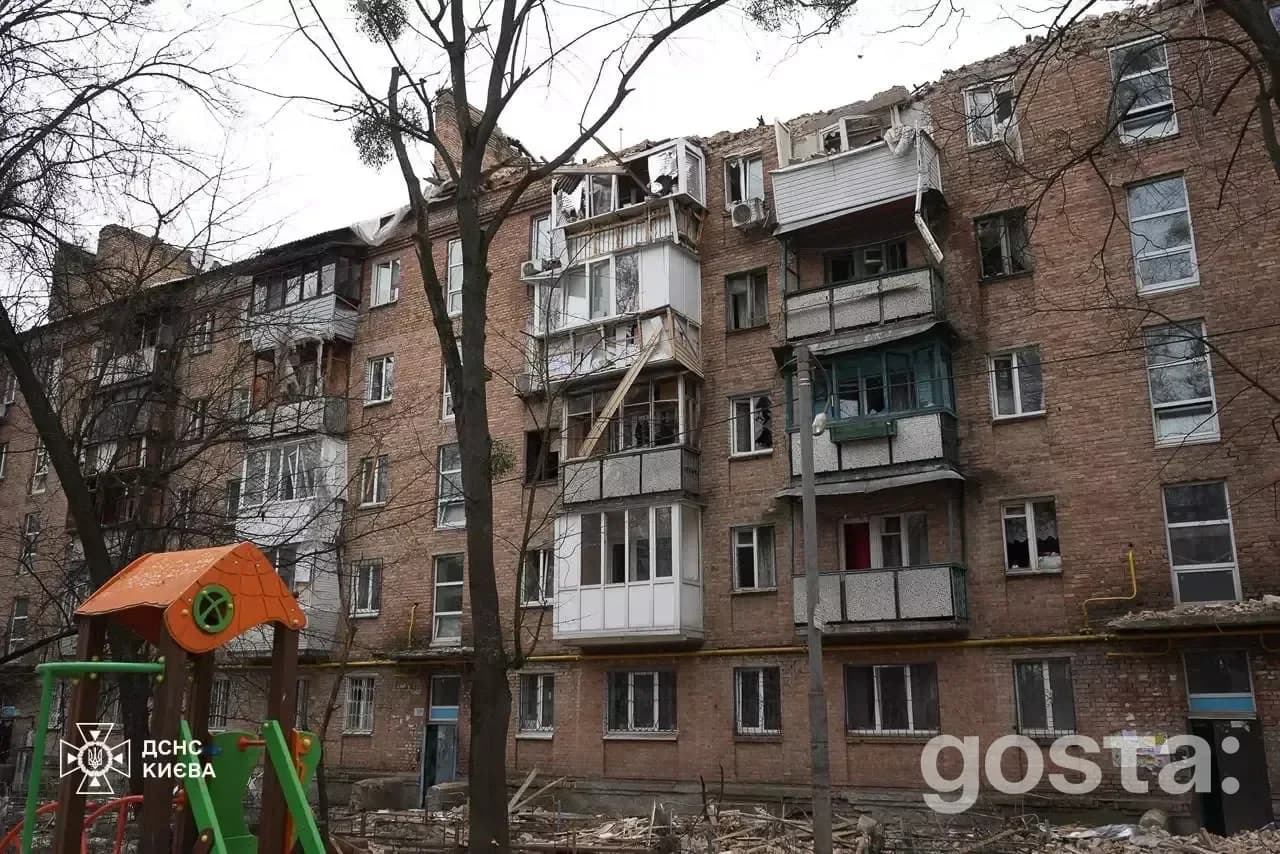 Damage to residential building in Kyiv after Russian attacks; rescue teams work on-site, addressing fires and impacts.