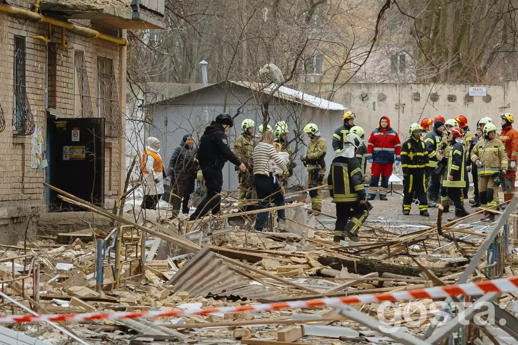Emergency responders and civilians work amidst destruction in Kyiv after a recent attack, aiding evacuation and recovery