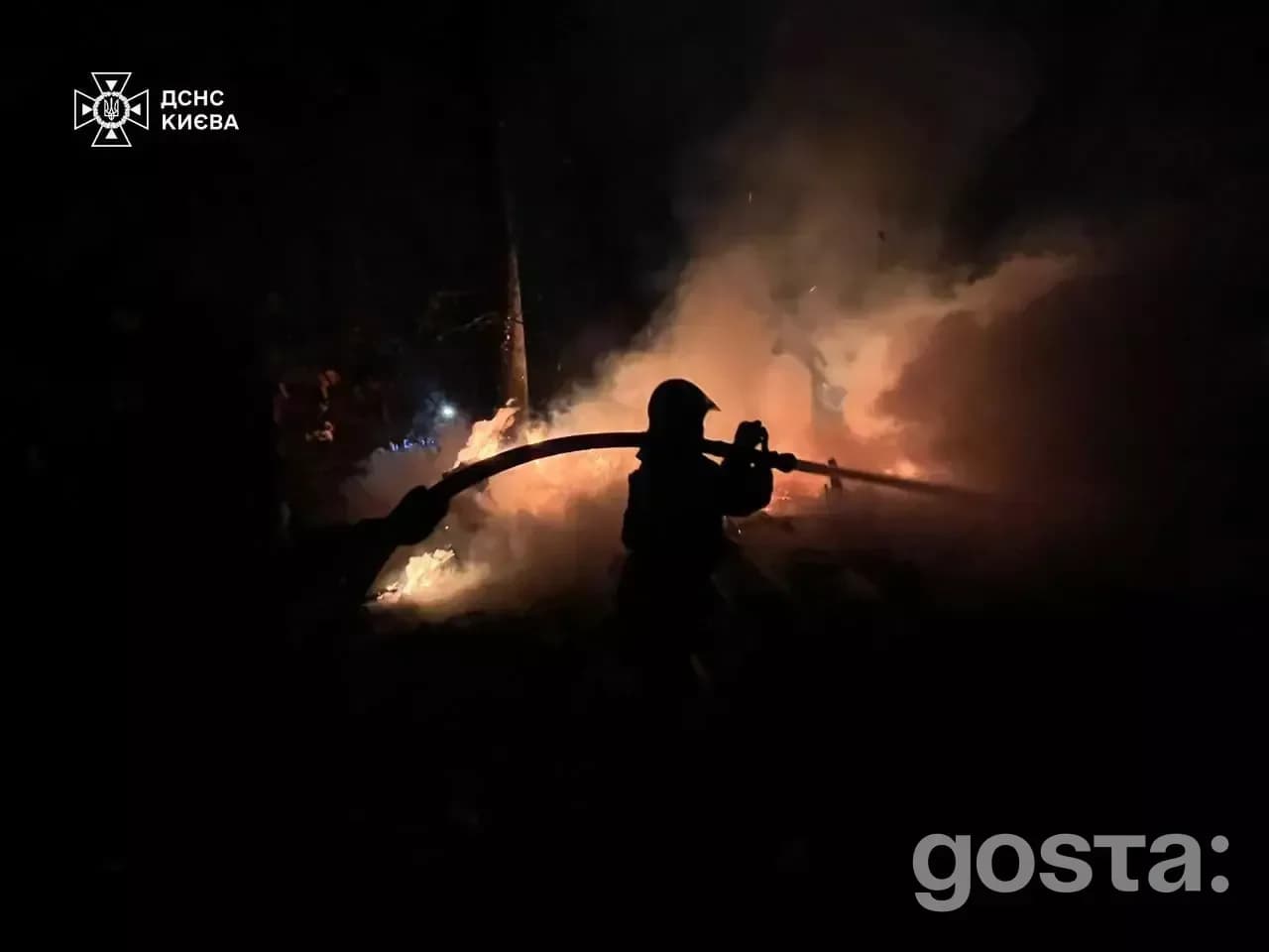 Firefighter extinguishing flames during a rescue operation after targeted attacks on vital infrastructure in Ukraine.