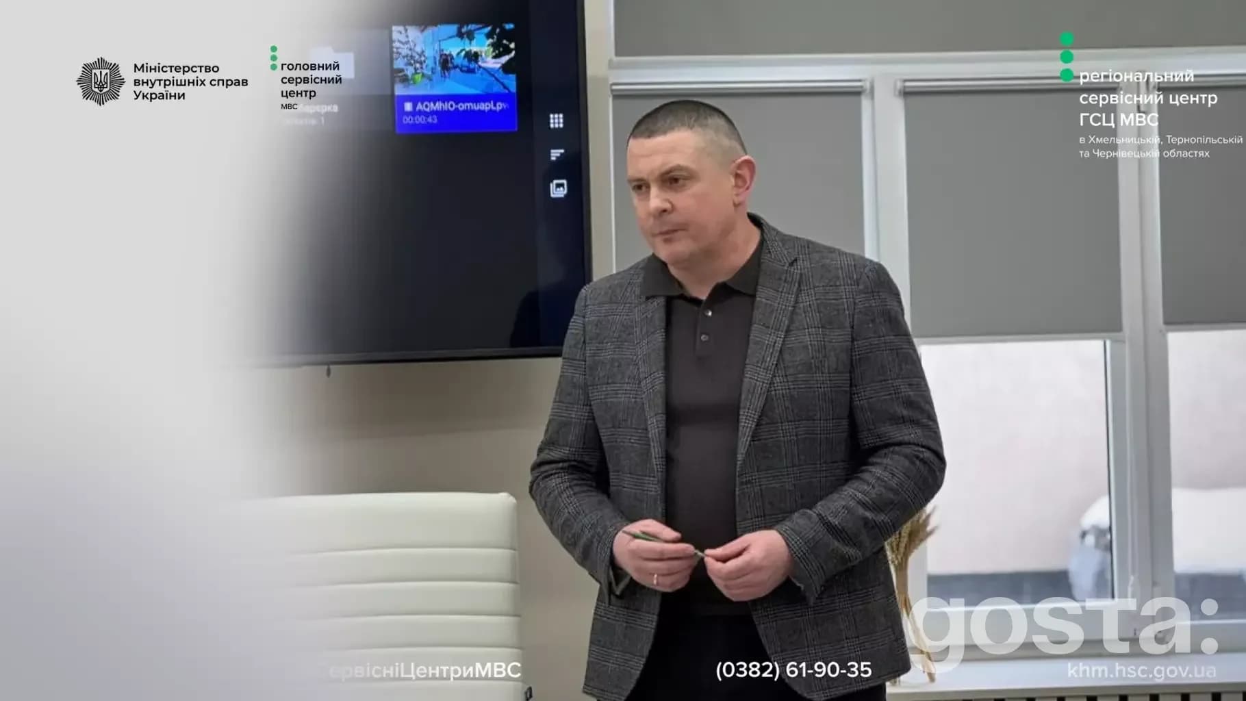 Не знаю, хто це.
Чоловік стоїть у приміщенні. На екрані логотип МВС України та інформаційний слайд.