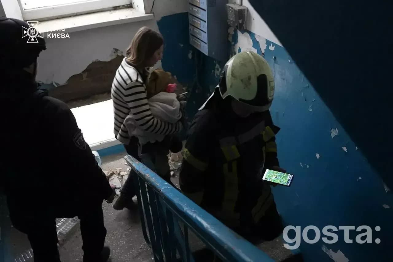 Rescue workers assist evacuees after a Russian attack in Kyiv, highlighting the urgent response to the disaster.