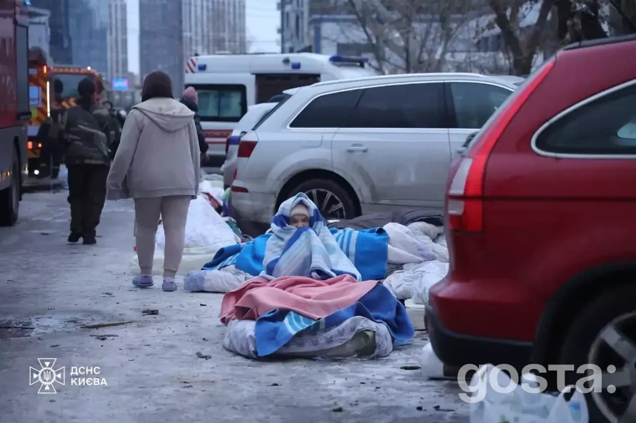 Rescue workers tend to injured victims covered with blankets after a Russian attack in Kyiv, highlighting the urgent cri