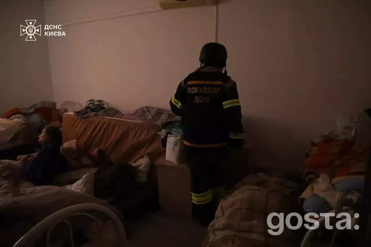 Rescuer assists survivors in a shelter after Russian attacks on Ukraine, documenting damages and extinguishing fires.