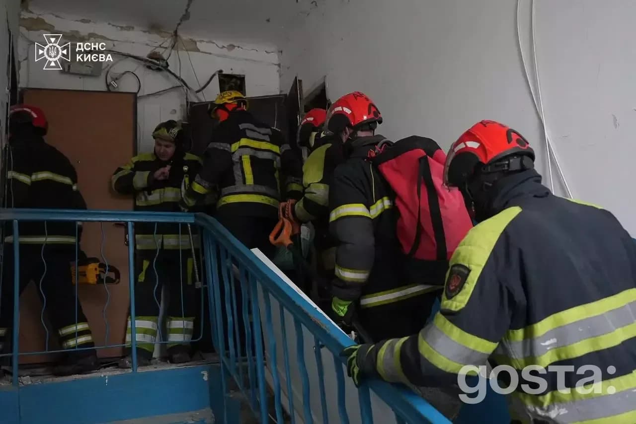 Rescuers and police respond to the aftermath of a Russian attack in Kyiv, aiding victims and extinguishing fires.